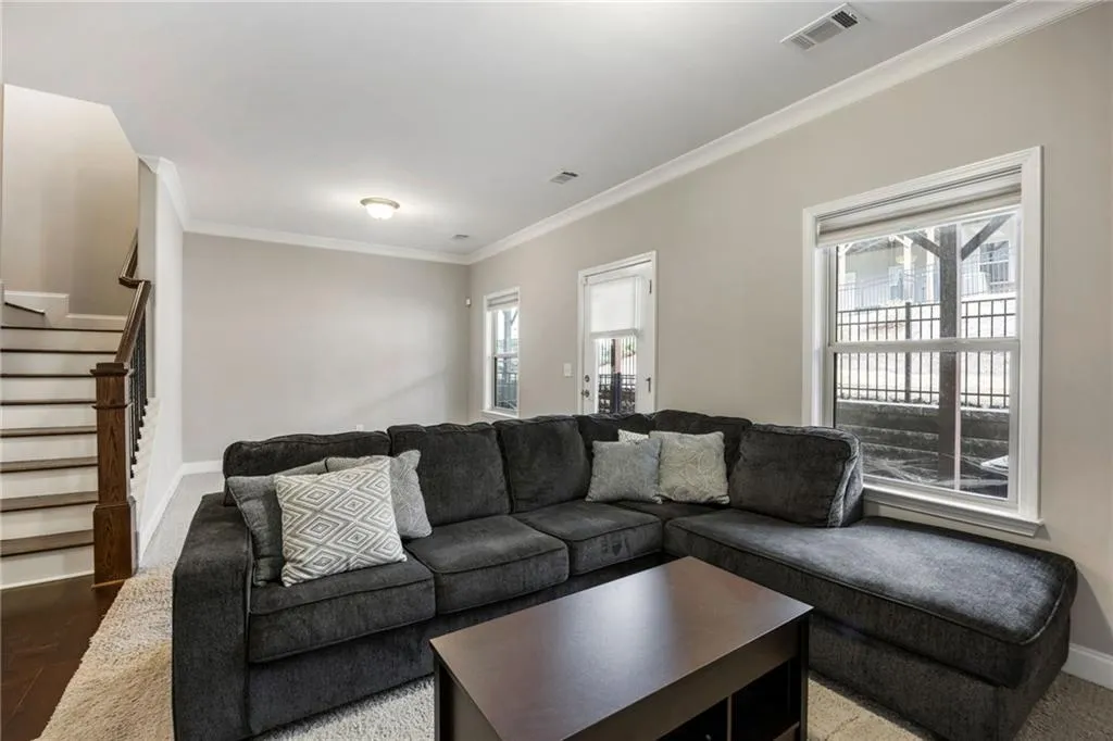 Living area with stairs and crown molding