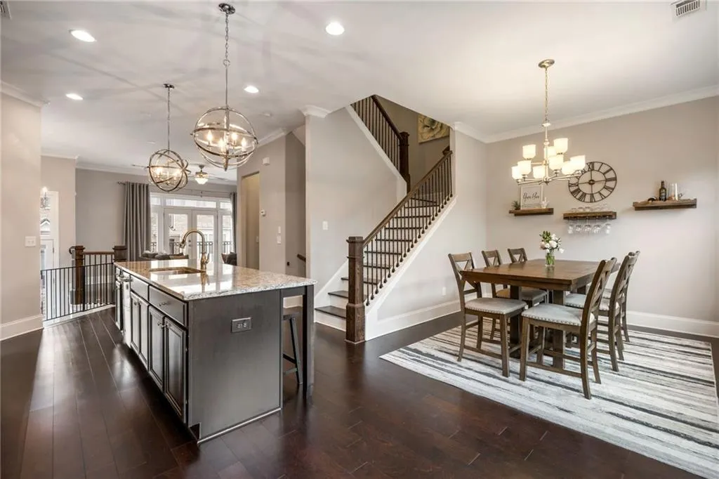 Dining room with stairs, a chandelier, ornamental molding, recessed lighting, and dark wood-type flooring