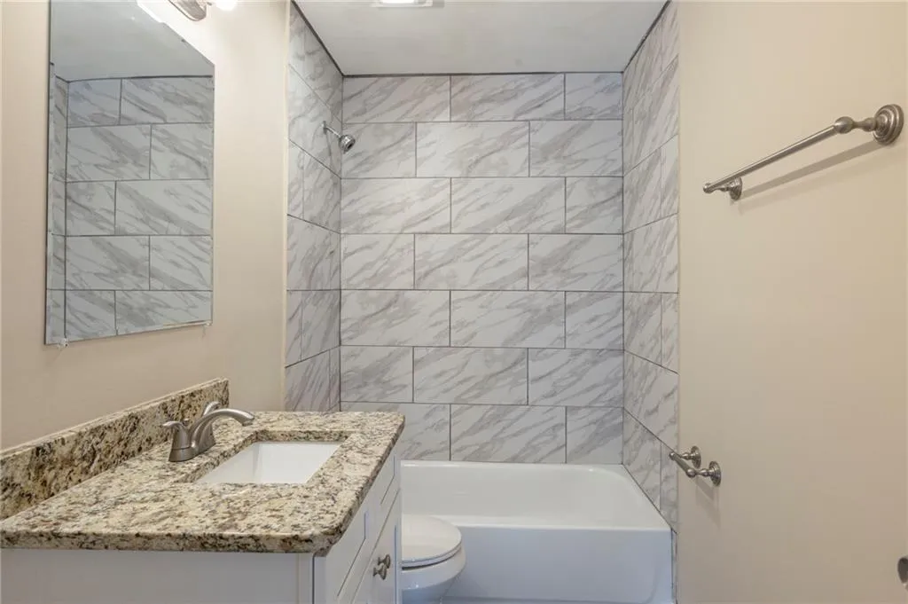 Bathroom featuring toilet, tub / shower combination, and vanity