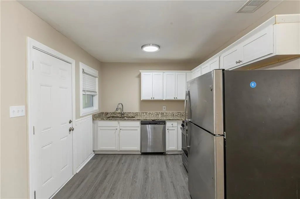 Kitchen featuring a sink, visible vents, white cabinets, appliances with stainless steel finishes, and light wood-type flooring
