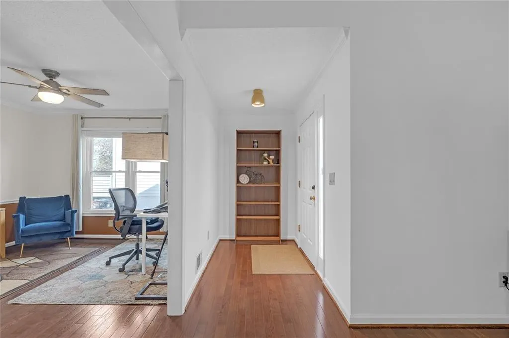 Entrance foyer featuring ceiling fan, hardwood / wood-style flooring, and ornamental molding