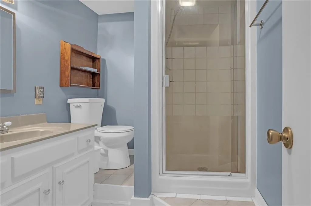 Full bath featuring vanity, a stall shower, and light tile patterned floors