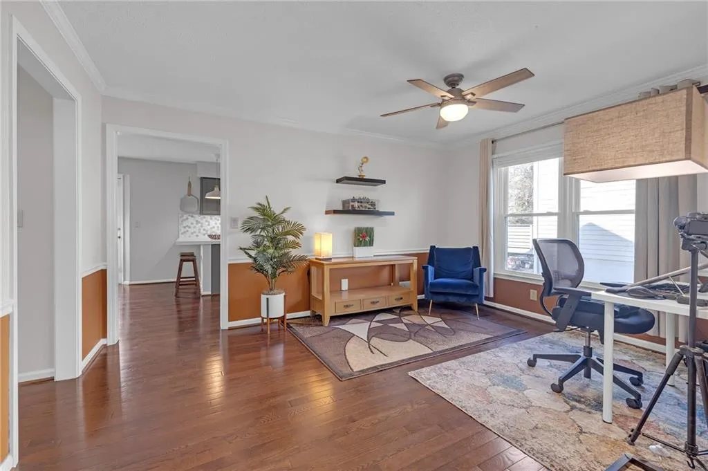 Office featuring crown molding, dark wood-style floors, and a ceiling fan