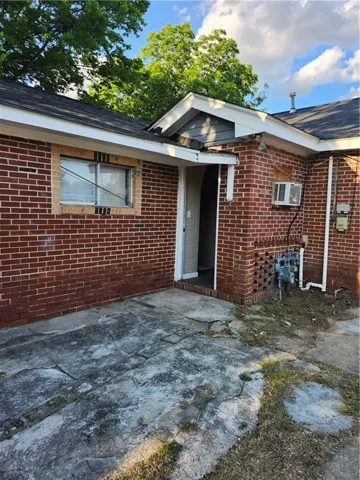 Brick exterior with dark shingle roofing