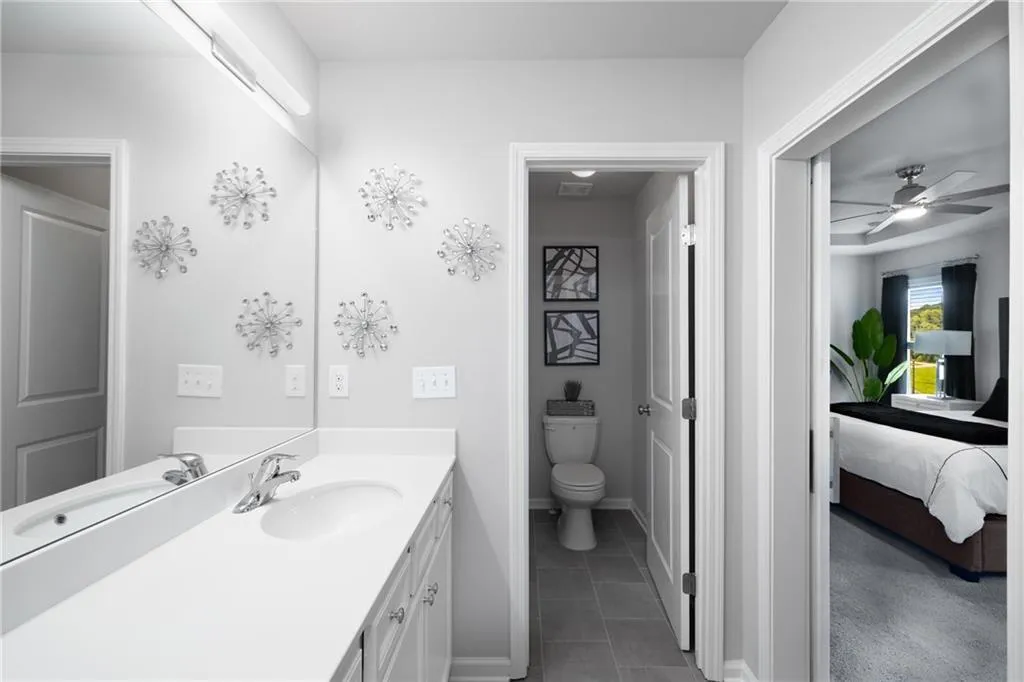 Bathroom featuring vanity, tile patterned flooring, a ceiling fan, and ensuite bathroom