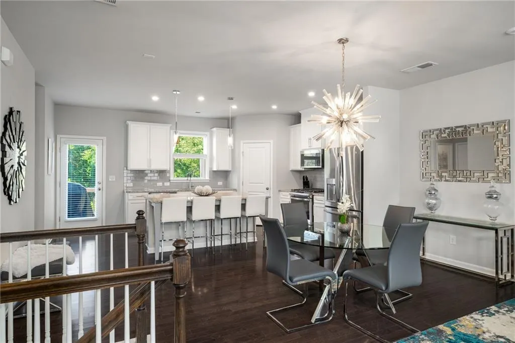 Dining room featuring dark wood-style flooring, a chandelier, and recessed lighting