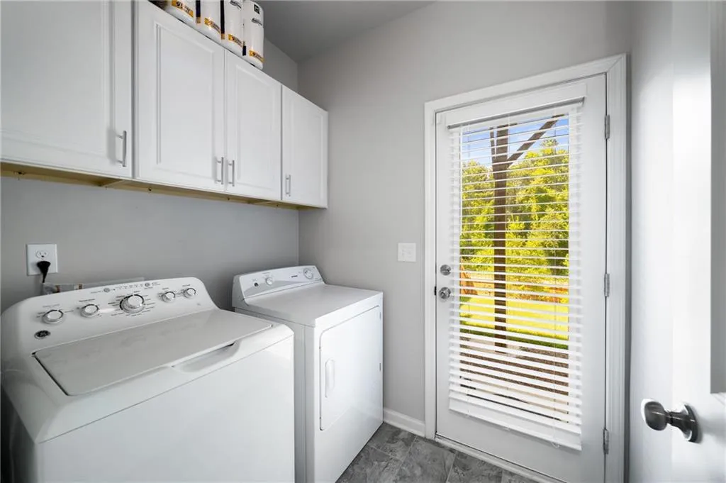 Washroom with cabinet space and washing machine and dryer