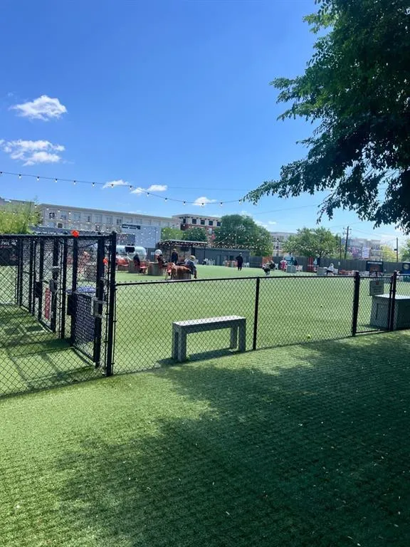 View of home's community with fence and a lawn