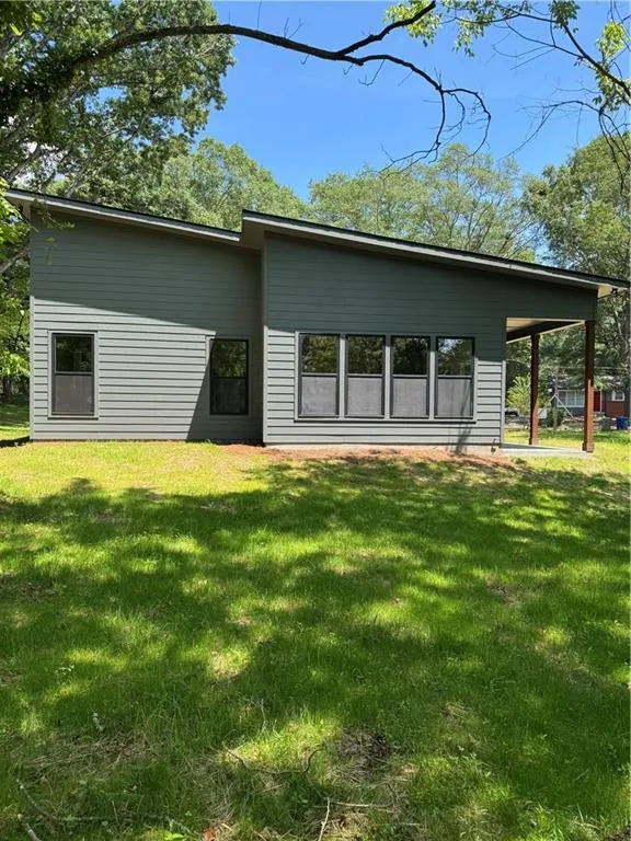 Rear view of property with a lawn
