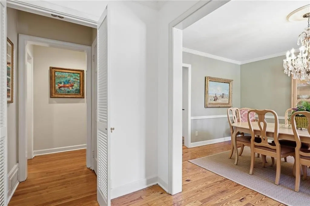Dining room with light wood-type flooring, suspended lighting, and crown molding