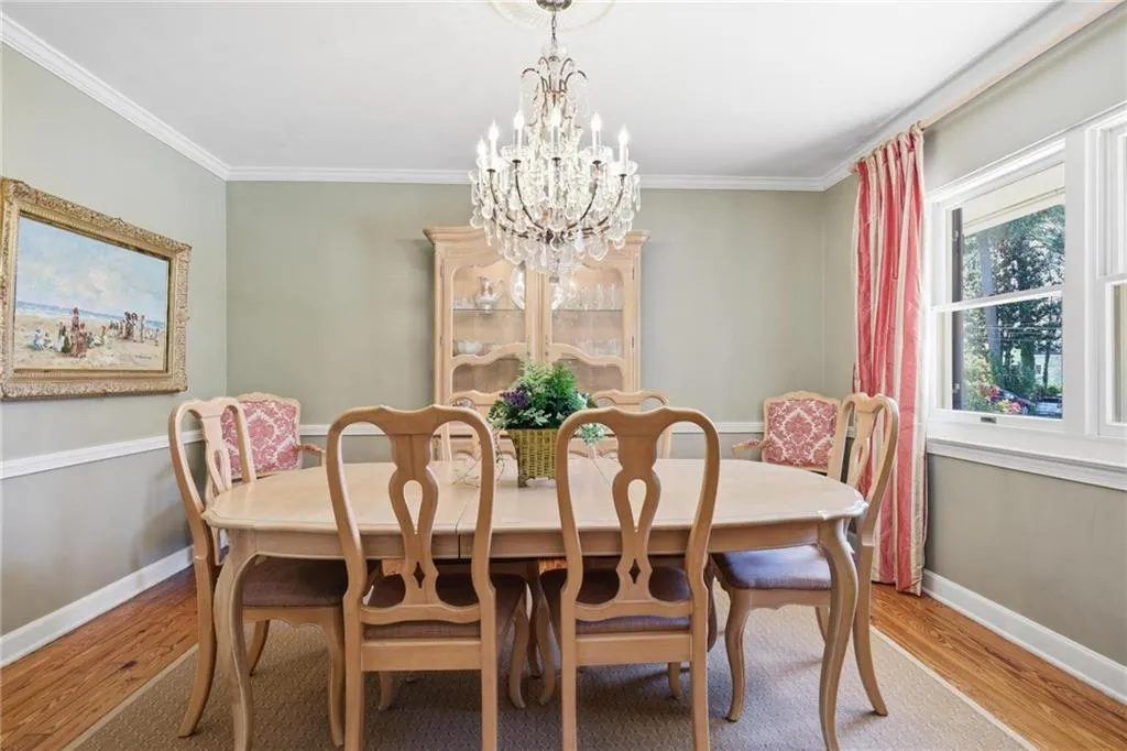 Dining room with a chandelier, wood finished floors, and ornamental molding
