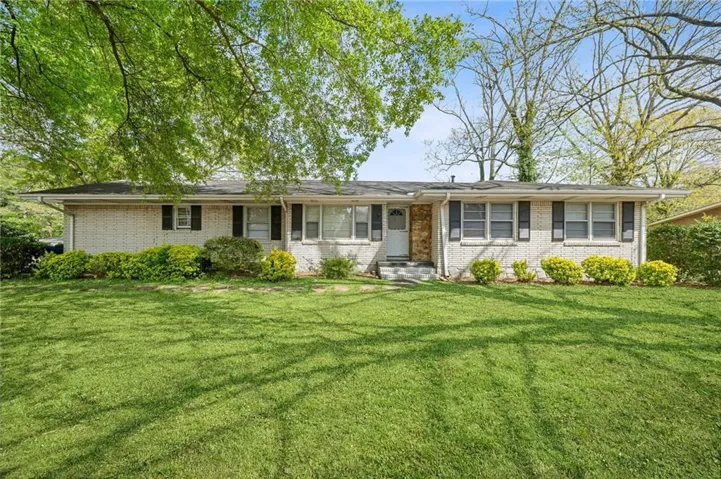 Ranch-style home featuring brick siding and a front lawn