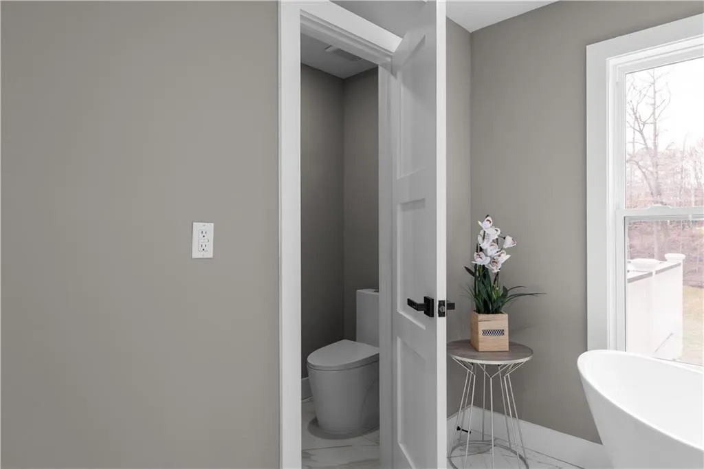 Bathroom featuring marble look tile flooring and a soaking tub