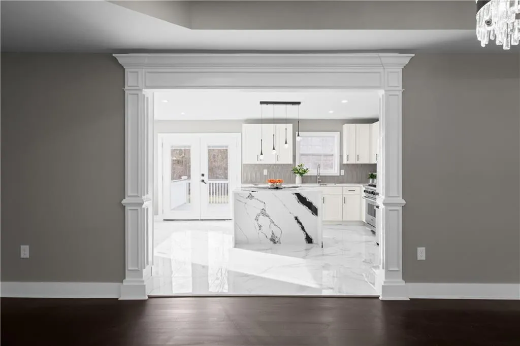 Kitchen featuring ornate columns, pendant lighting, white cabinets, and high end stainless steel range