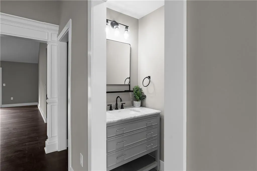 Half bath with vanity and dark wood-style flooring