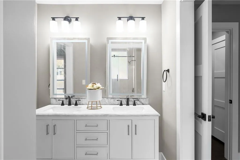 Full bathroom with double vanity and a stall shower