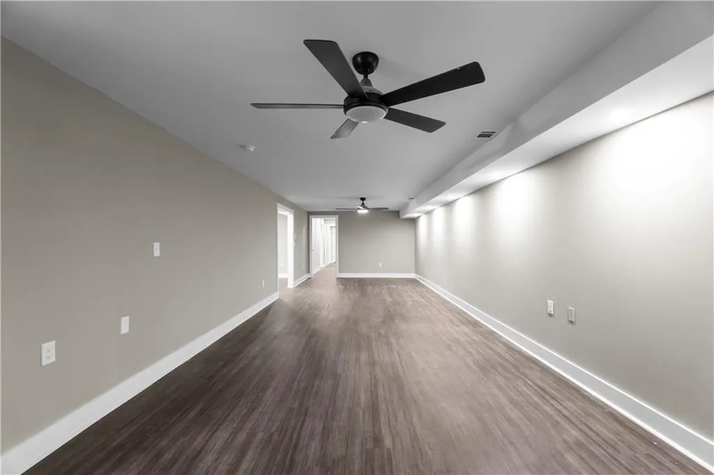 Spare room featuring ceiling fan and dark wood-type flooring