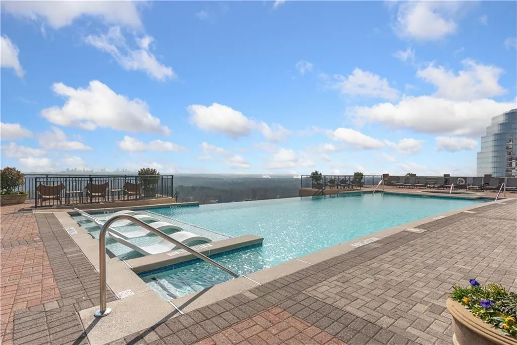 Community pool featuring a jacuzzi and a patio area