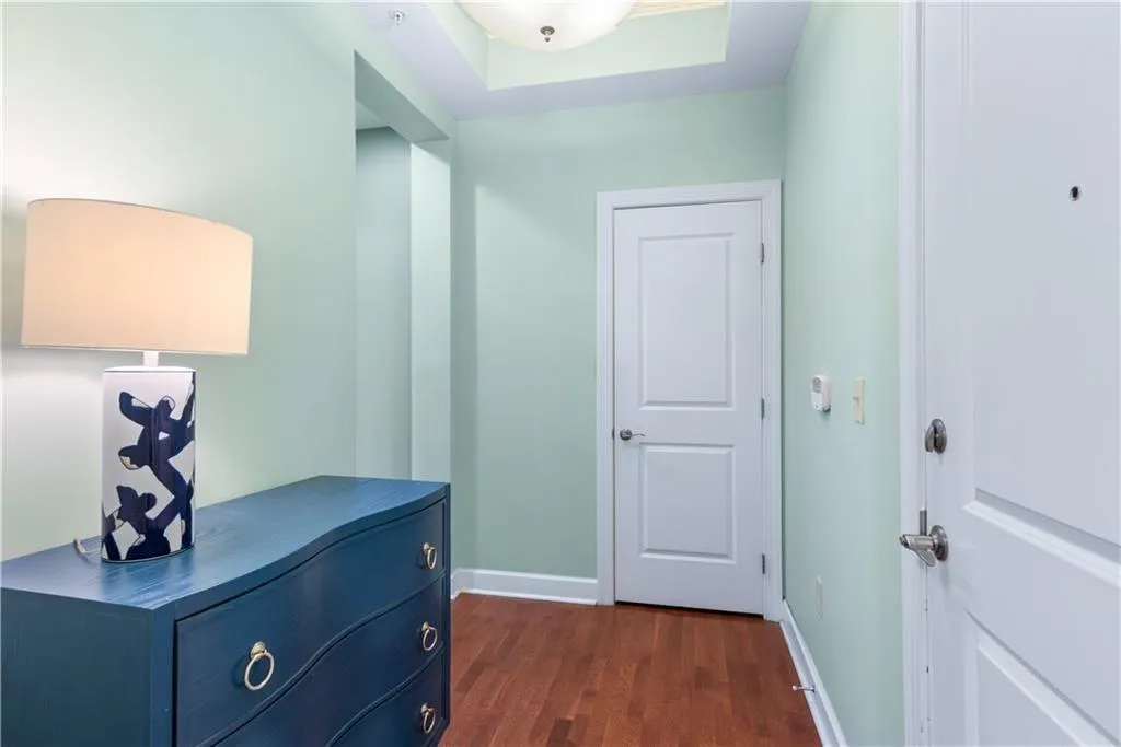Hallway featuring dark wood-style flooring and baseboards