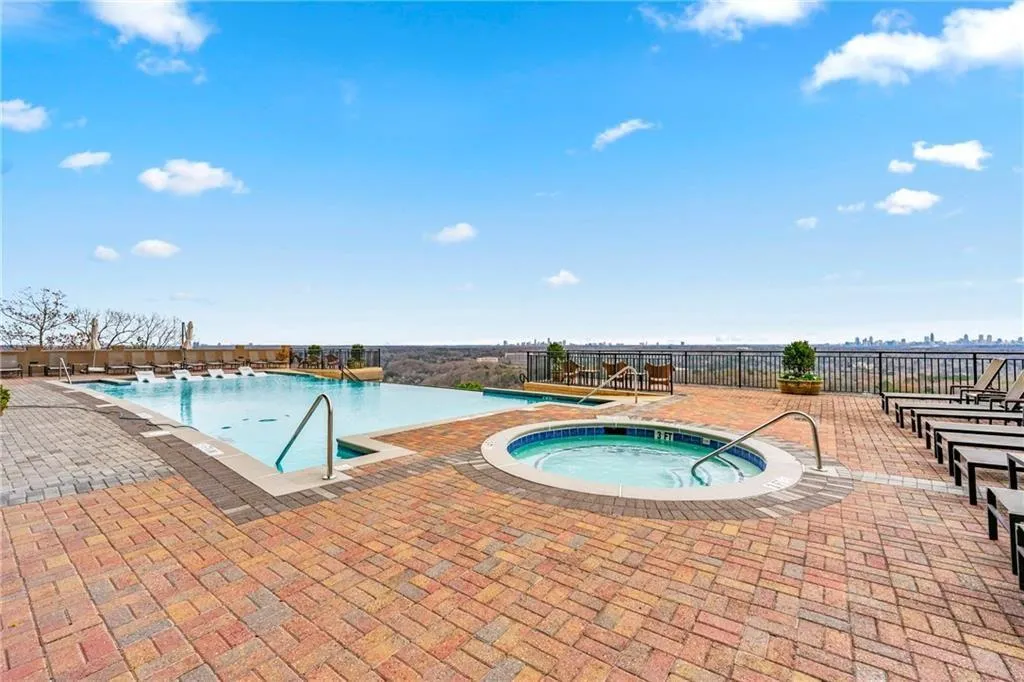 Community pool with a patio area and a community hot tub