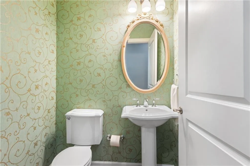 Bathroom with toilet and wallpapered walls