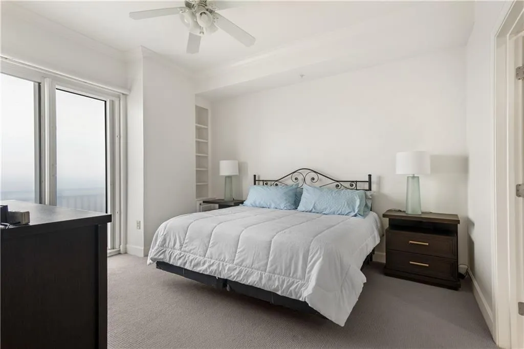 Carpeted bedroom featuring crown molding, ceiling fan, and access to exterior