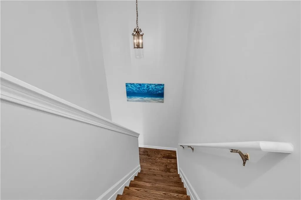 Stairway with wood finished floors and baseboards