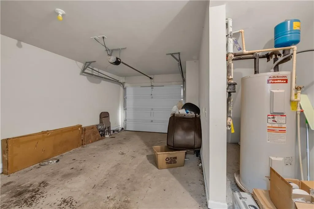 Garage featuring water heater and a garage door opener