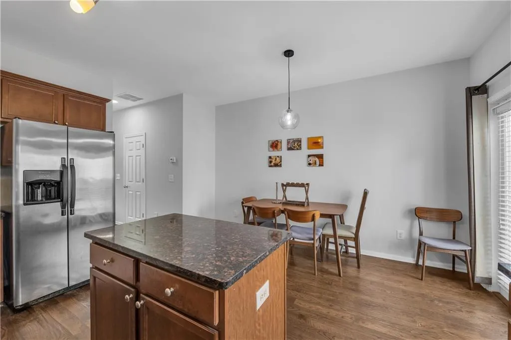Kitchen with stainless steel fridge, dark wood finished floors, a center island, and plenty of natural light