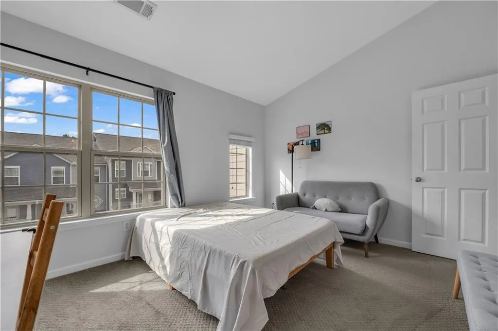 Bedroom featuring carpet and vaulted ceiling