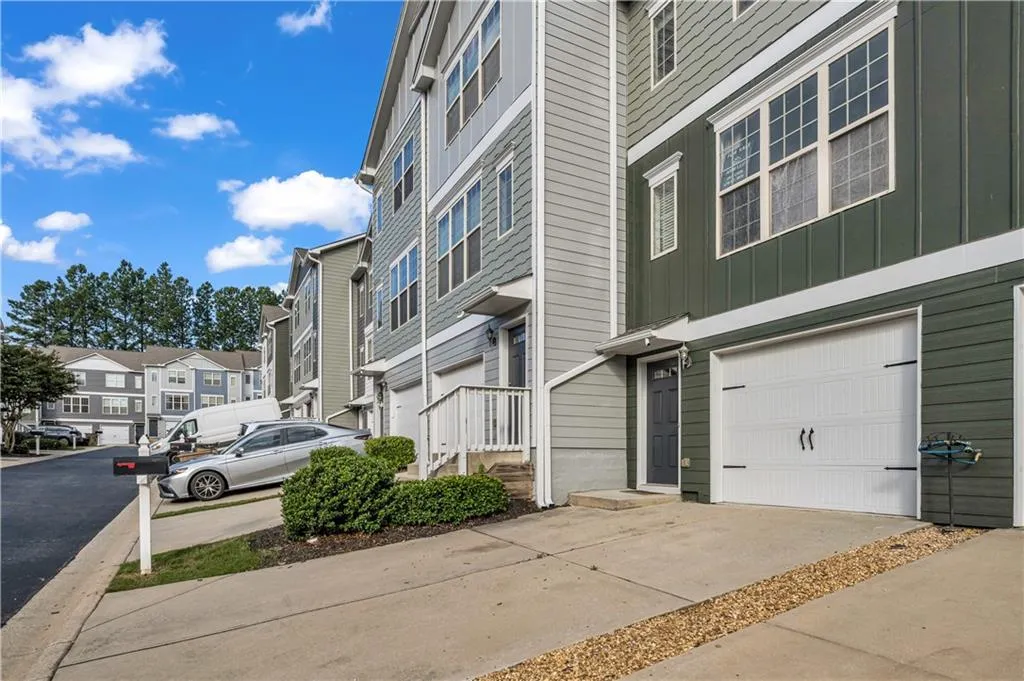View of property featuring an attached garage, a residential view, and driveway