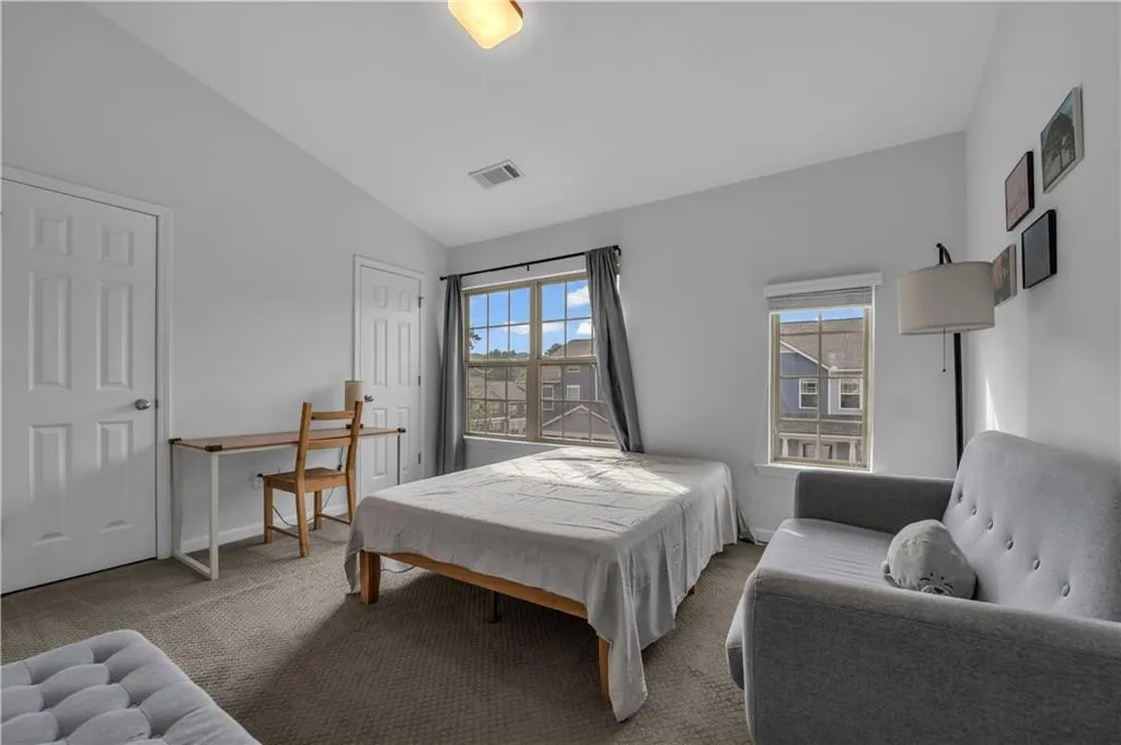 Bedroom featuring carpet flooring and lofted ceiling