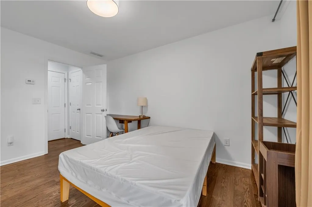 Bedroom with dark wood-style floors and baseboards
