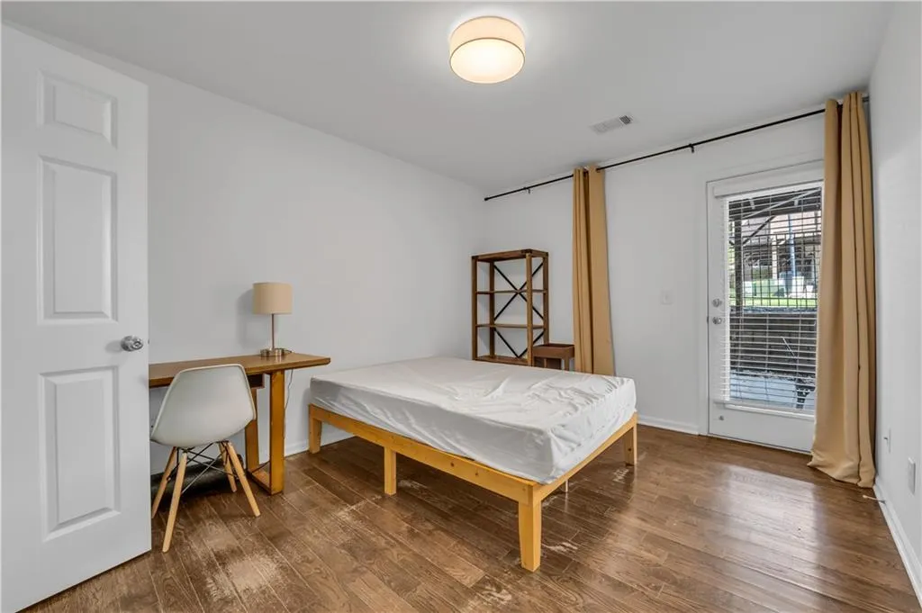 Bedroom with wood finished floors and access to outside