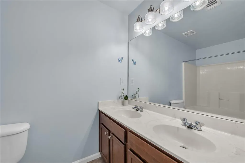 Full bathroom with double vanity and shower / bathtub combination