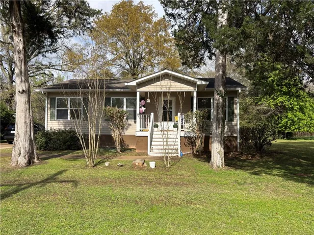 Modern Ranch-style residence featuring generous front yard and covered front porch with swing and white railing