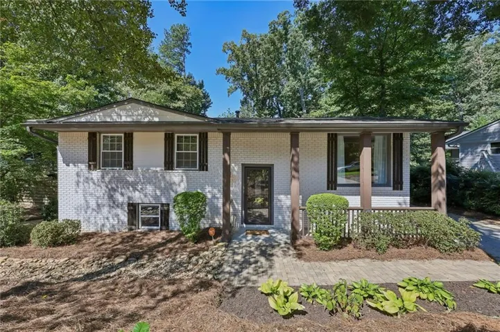 Brick exterior with painted finish, covered front entry, and wood-finish support columns