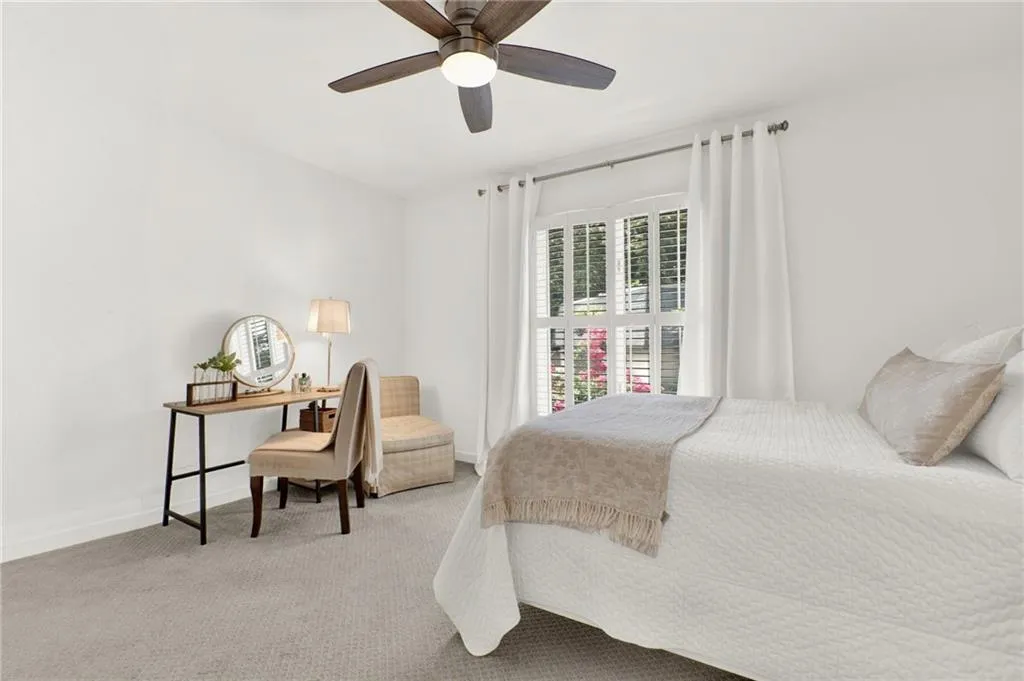 Carpeted bedroom featuring baseboards and a ceiling fan
