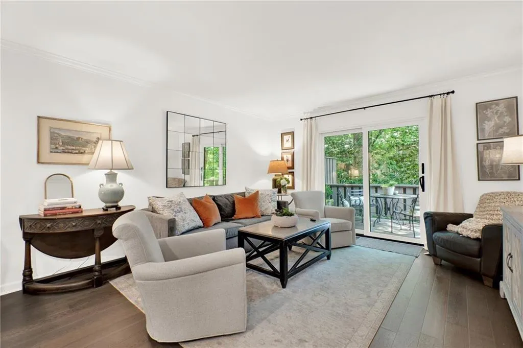 Living area with ornamental molding and wood-type flooring