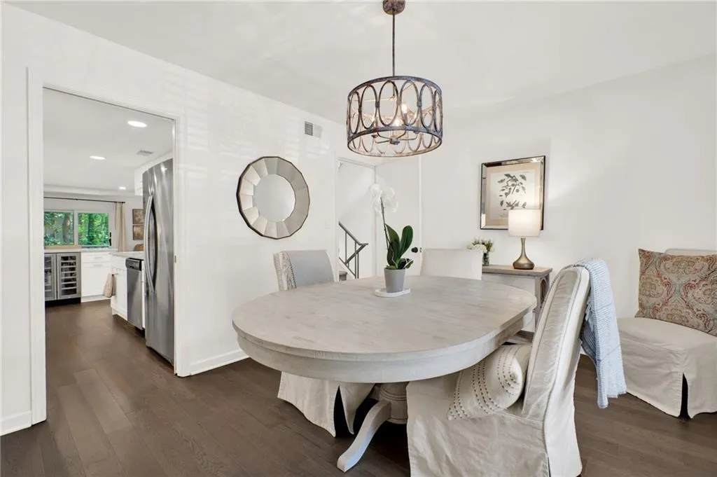 Dining room featuring wine cooler, dark wood-style floors, a chandelier, and recessed lighting
