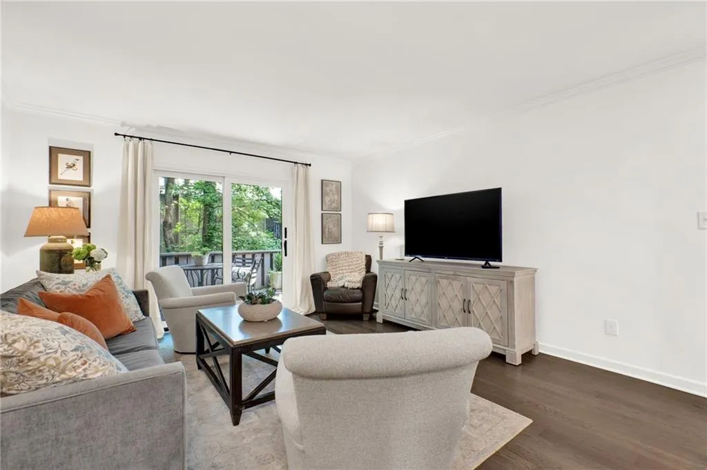Living room with ornamental molding and dark wood finished floors