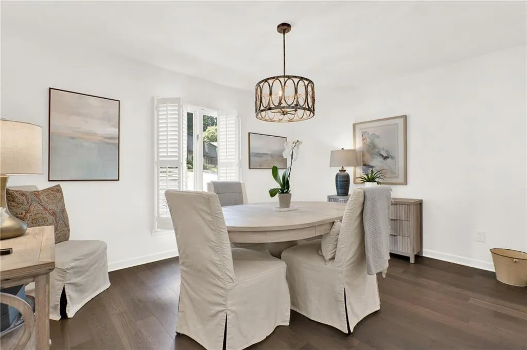 Dining space with a chandelier and dark wood-style flooring