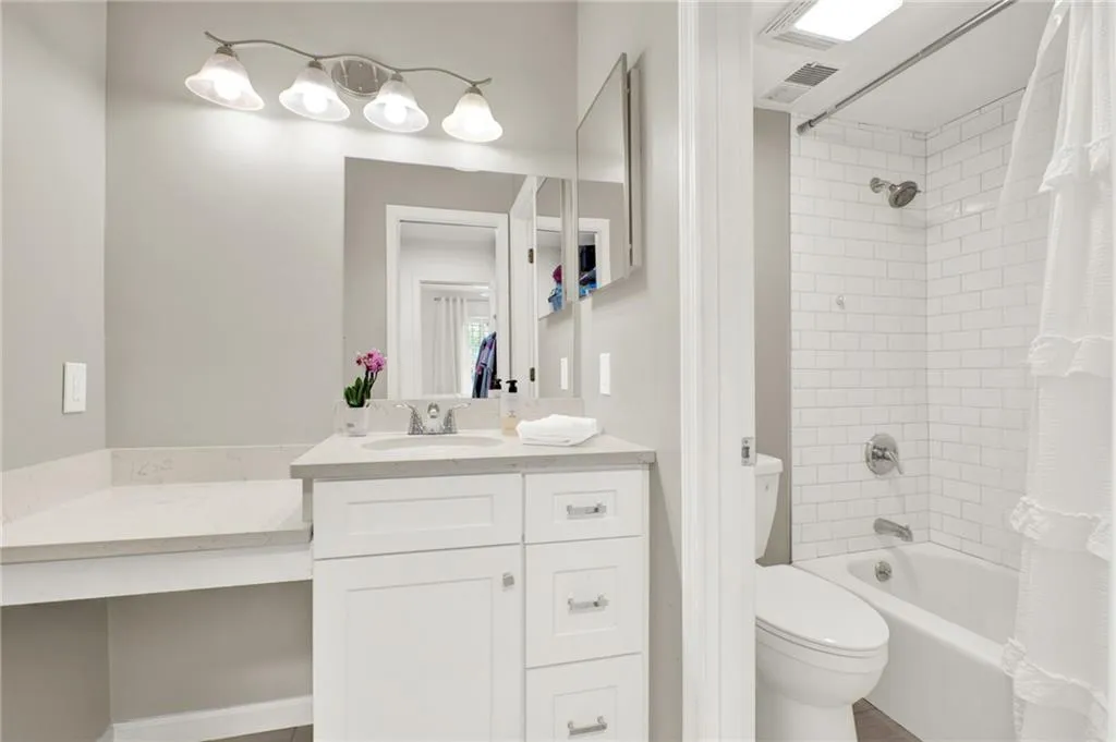 Bathroom featuring vanity and shower / bath combination with curtain