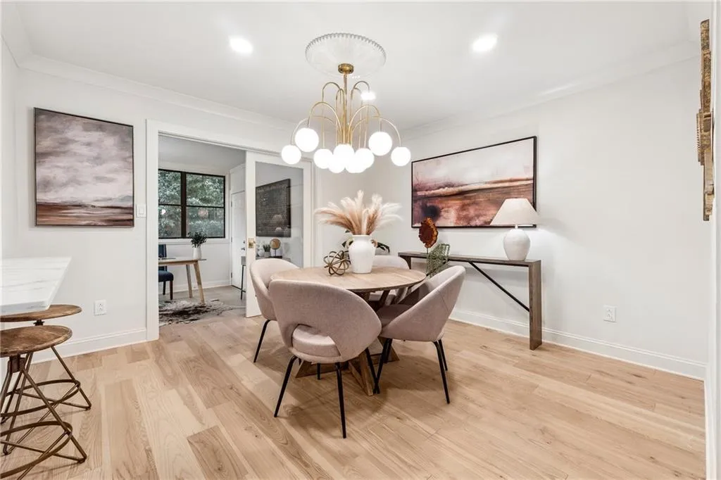 Dining area featuring hanging lights, light wood-type flooring, and ornamental molding
