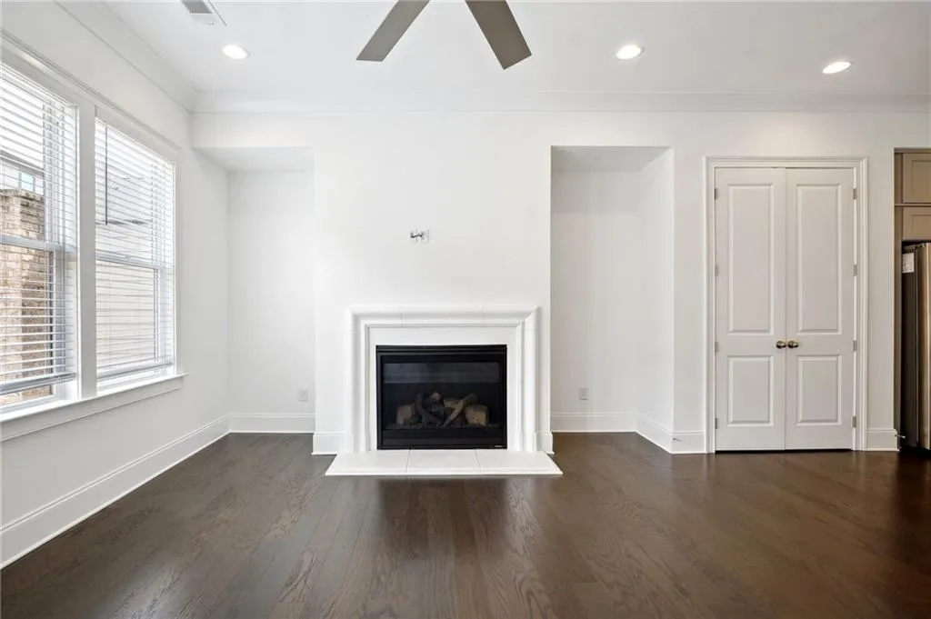 Unfurnished living room with ornamental molding, dark wood-type flooring, and a wealth of natural light