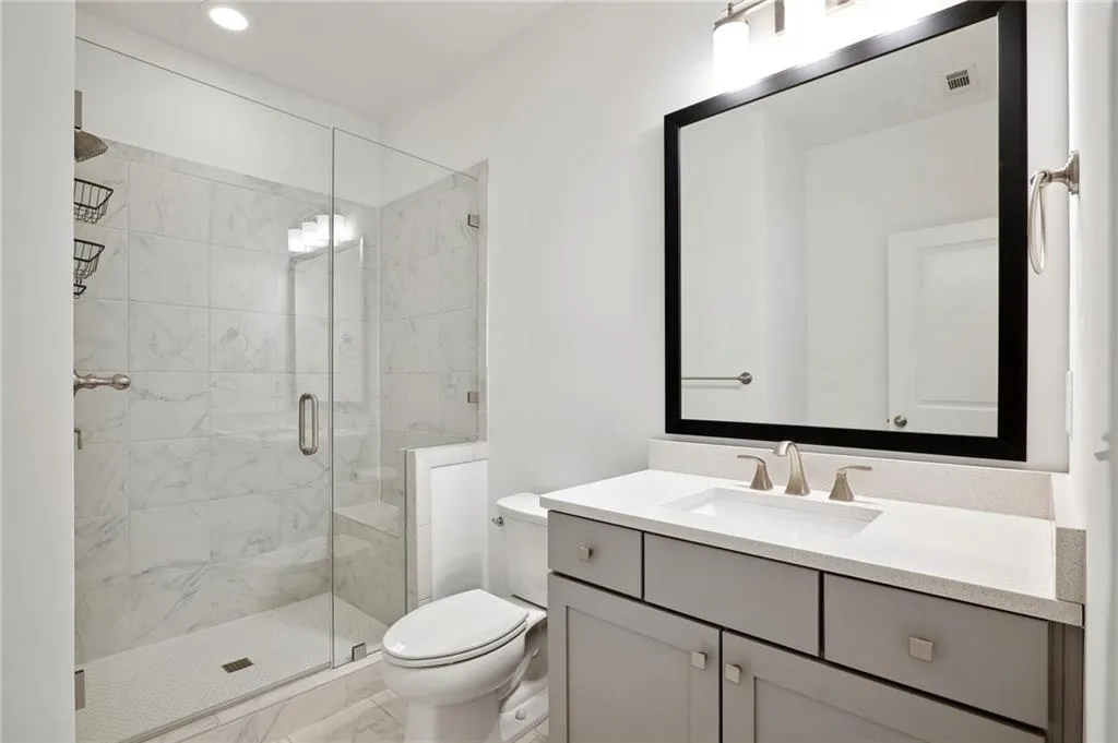 Bathroom featuring vanity, toilet, and walk in shower