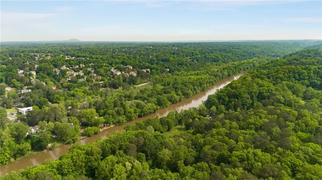 Aerial view featuring a wooded view and a water view