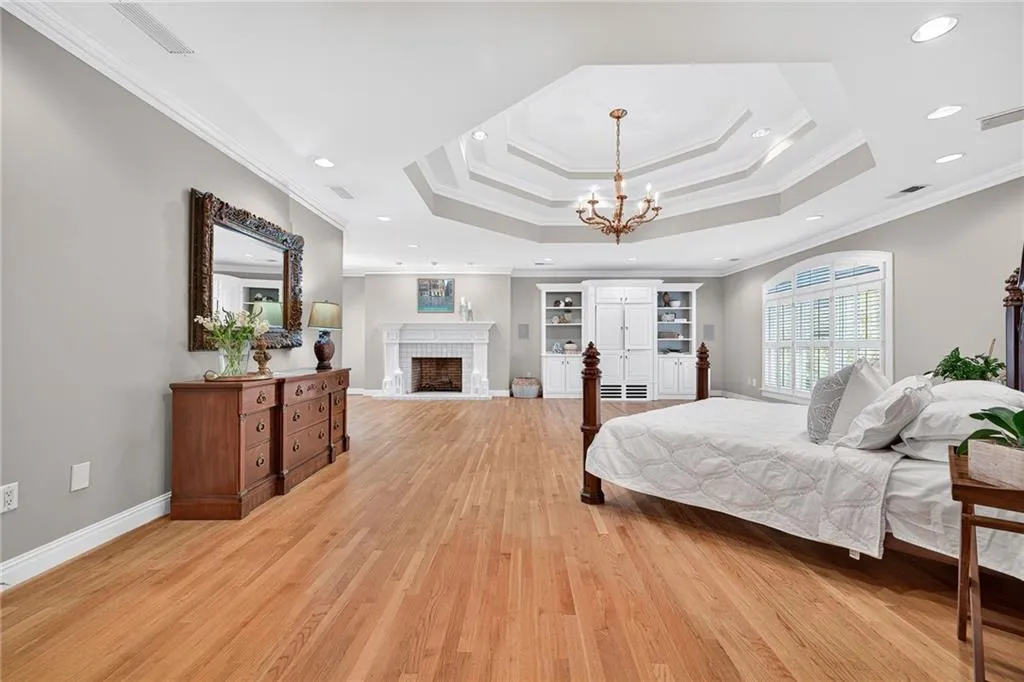 A dream master bedroom with fireplace, built-in shelving and sitting room