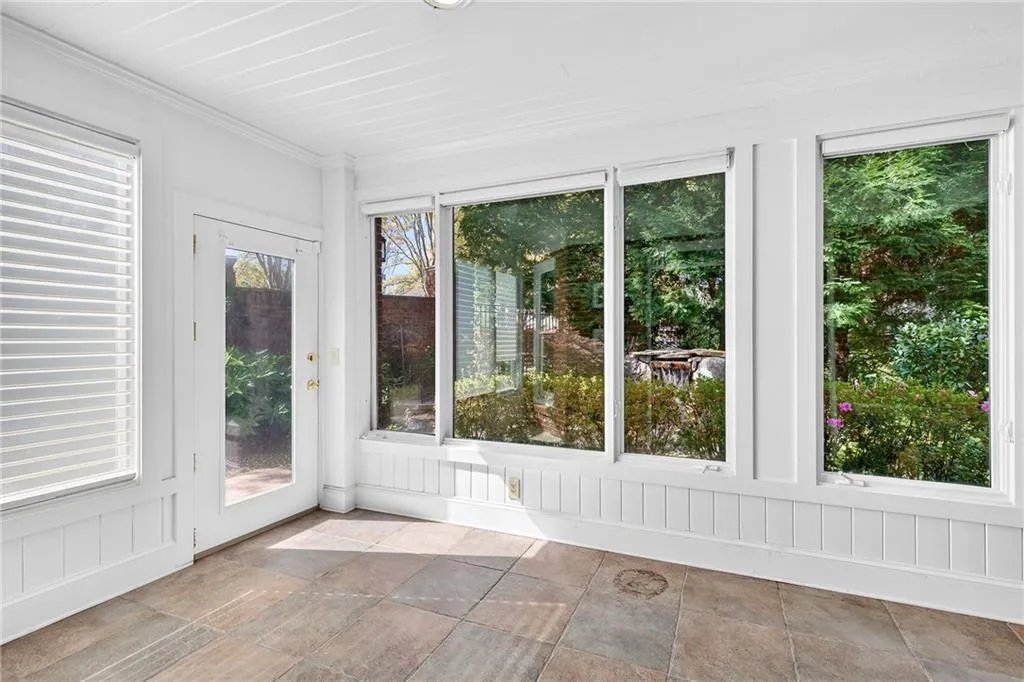 Terrace level sunroom with view of outdoor pond