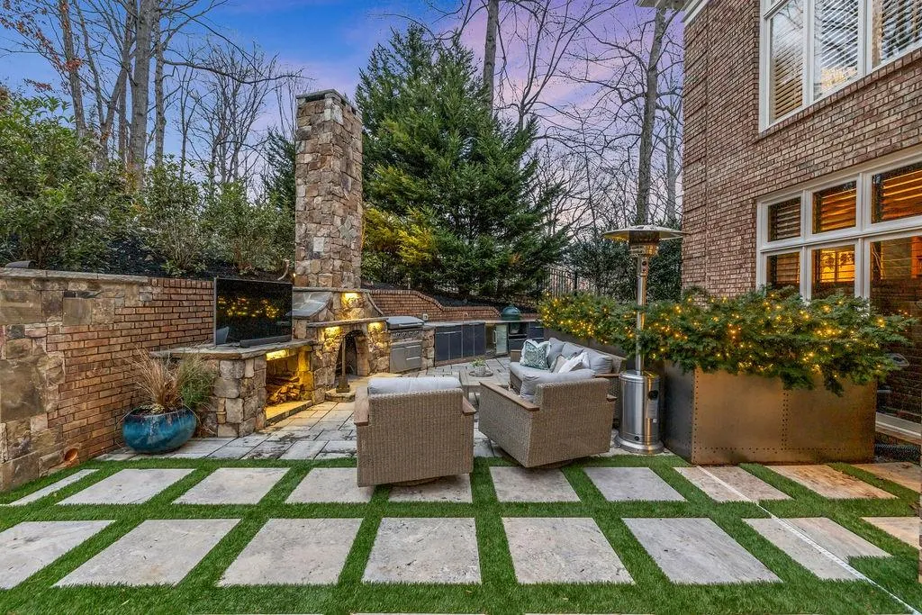 Outdoor Kitchen Features a Stone Fireplace, Quartzite Counters & Built-In Appliances